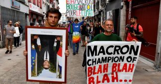 Hundreds protest Macron’s climate policies, carrying STOLEN portraits of him upside-down