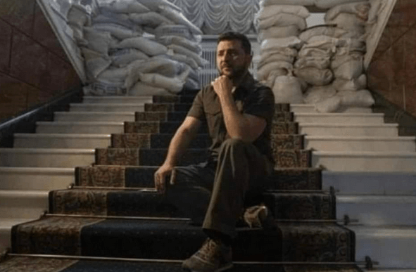 Zelenski, while his country is destroyed