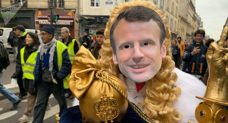 Un roi de France portant un masque de Macron en tête du cortège des Gilets jaunes à Paris